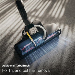 Close-up of a 2-Miele Boost CX1 Cat & Dog vacuum cleaner head with a rotating brush on carpet, featuring a caption that reads, “Additional TurboBrush for pet hair removal included with the 2-Miele Boost CX1 Cat & Dog bagless vacuum cleaner.”.