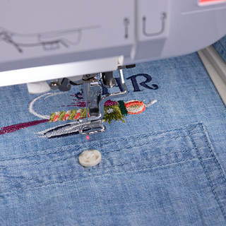 A Baby Lock Altair 2 Sewing & Embroidery Machine with IQ Technology is embroidered on a blue shirt.