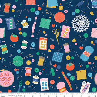 Hand Made by Riley Blake C16590-NAVY Notions Navy Fabric from Fabric by Riley Blake features colorful sewing and knitting supplies like quilting fabric, buttons, thread, needles, and more on a dark blue background with a ruler at the bottom.