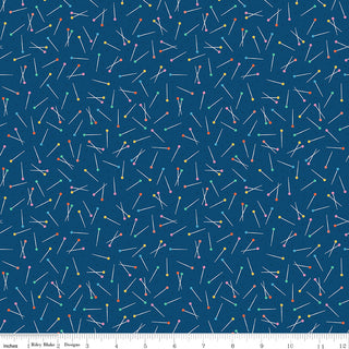 Hand Made by Riley Blake C16594-NAVY Pins Navy Fabric from Fabric by Riley Blake features colorful straight pins with round heads on a dark blue background, ideal for quilting or apparel. Inch ruler markings appear along the bottom edge of the image.