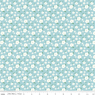 Serendipity 2 by Minki Kim C17304-POWDER Flower Bed Powder fabric by Riley Blake features light blue quilting cotton with small white flowers and green leaves, perfect for keepsake sewing or nostalgic projects. Measuring tape shown along fabric edge.