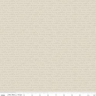Leo & Savannah by Deena Rutter C17543-SAND Text Sand Fabric Yardage by Riley Blake is a cream cotton quilting fabric with small light brown script text, 44" wide, sold by the yard. Ruler in image shows inches.