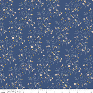 Danelys Sidron for RBD Before the Bloom C18062-DENIM Astrid Denim by 56-Riley Blake features a repeating pattern of white and yellow flowers with green stems on a blue background. A ruler at the bottom displays inch measurements from 0 to 12. This premium cotton fabric is perfect for quilting projects, offering vibrant color and quality you’ll love working with.