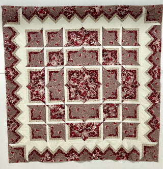 A Sew & Vac Costa Maya Quilt- (sew- Karrie Lawrimore) with a red and white design featuring various fabric prints, including blenders.