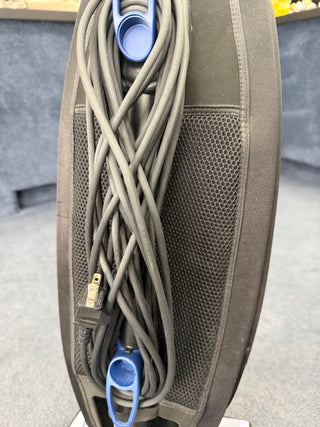 The Sew & Vac Oreck Magnesium LW1500RS (Certified Refurbished) vacuum cleaner, with a new HEPA bag, features its power cord neatly wrapped around blue hooks on the back.