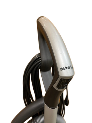 Close-up of the Miele Dynamic U1 Fresh Air PowerLine handle with control buttons, AirClean filters, and a coiled cord, available from Imagine Sewing & Vacuum.