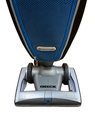 A close-up of the base and lower body of the lightweight blue and silver Oreck Magnesium LW100 upright vacuum cleaner by Imagine Sewing & Vacuum.
