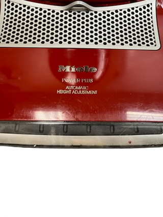 Close-up of a red Imagine Sewing & Vacuum Miele Salsa Upright with "Automatic Height Adjustment" text on the front, now featuring new filters for improved performance.