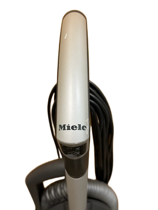 Top view of the Imagine Sewing & Vacuum Miele Salsa Upright handle, with a coiled power cord visible in the background.