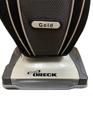 A close-up of the base and lower body of the Imagine Sewing & Vacuum Oreck Gold Upright, highlighting its brushroll.