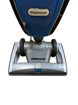 Oreck Magnesium used vacuum cleaner by Imagine Sewing & Vacuum, featuring a blue and silver body, shown from the front against a white background.
