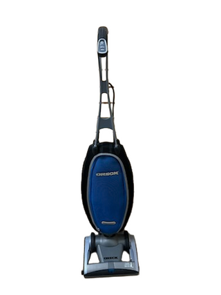 The Oreck Magnesium upright vacuum cleaner by Imagine Sewing & Vacuum features a blue bag, black handle, and gray base, pictured standing upright against a white background.