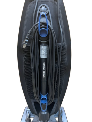Close-up of the Oreck Magnesium’s back by Imagine Sewing & Vacuum, featuring a coiled power cord neatly wrapped around its carry handle—ideal for upright vacuum fans.
