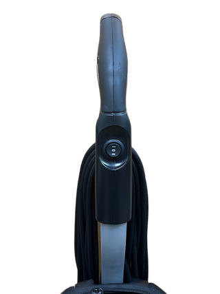 Close-up view of the handle and power switch of the Riccar R10P lightweight vacuum cleaner by Imagine Sewing & Vacuum, showing the cord neatly wrapped around its holder.
