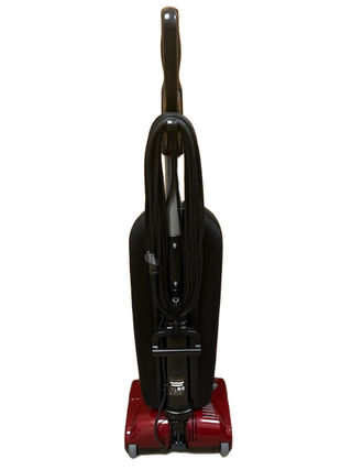 The Riccar R10P by Imagine Sewing & Vacuum is a red upright lightweight vacuum with a black cord wrapped around the handle, displayed from the front against a white background.