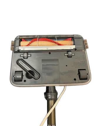 The underside of the Oreck XL Element vacuum head by Imagine Sewing & Vacuum reveals its brush roll, wheels, and release latch on a white background—perfect for hard flooring.