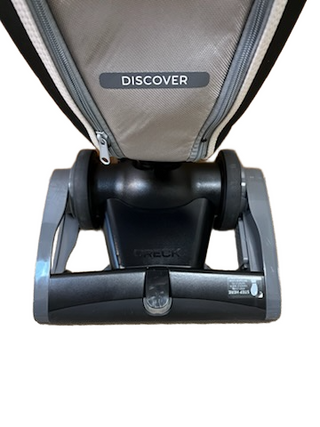 Close-up of the base of a refurbished Oreck Discover vacuum cleaner from Imagine Sewing & Vacuum, showing wheels and a portion of the cleaning head.