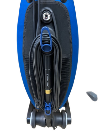 The Oreck Magnesium LW100 by Imagine Sewing & Vacuum is a blue upright vacuum with a wrapped cord, visible carry handle, never-ending belt, and labeled high/low control switch.