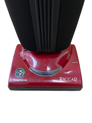 Red Riccar R10P vacuum cleaner base, featuring a logo and certification badge on the left side, this lightweight refurbished model from Imagine Sewing & Vacuum is designed for easy maneuverability and reliable performance.