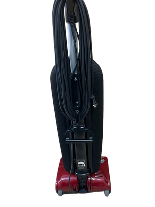 Refurbished Imagine Sewing & Vacuum Riccar R10P red upright vacuum cleaner featuring a black dust bag and coiled black power cord, photographed against a white background. This lightweight model is ideal for efficient and effortless cleaning.