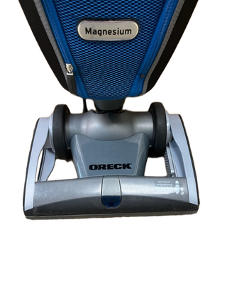 Close-up of the Imagine Sewing & Vacuum Oreck Magnesium vacuum cleaner, highlighting its lightweight base and lower front section against a white background.
