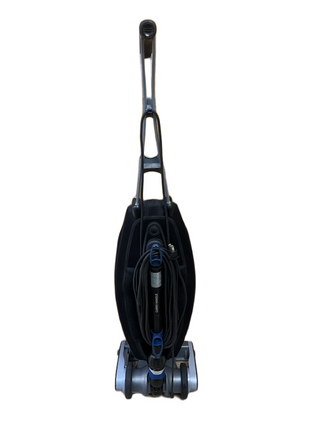 Refurbished Description: Upright vacuum cleaner with a black body, handle, wrapped power cord, and wheels, shown from the front against a white background—this lightweight Oreck Magnesium vacuum by Imagine Sewing & Vacuum has been expertly refurbished for reliable performance.