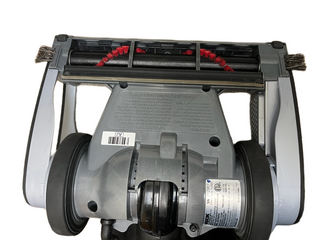 Bottom view of the Imagine Sewing & Vacuum Oreck Magnesium vacuum cleaner head, displaying its brush rollers, two wheels, barcode, and product information label on a white background—emphasizing the unit’s lightweight design.