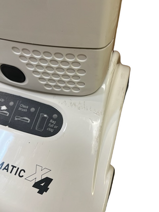 Close-up of a white, refurbished Sebo X4 vacuum showing scuff marks on the side casing.