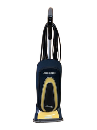 Oreck XL Gold lightweight, upright vacuum cleaner with a black bag, a yellow accent panel, and a cord wrapped around the handle.