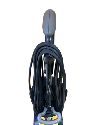 Close-up of an Oreck XL Gold vacuum cleaner handle with a power cord wrapped around the hooks.