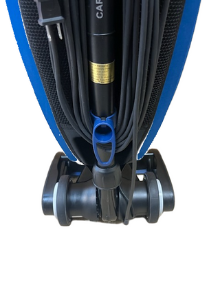 Close-up of a reconditioned Oreck Magnesium LW100 vacuum showing the cord wrapped around the handle and the rear wheels at the base.