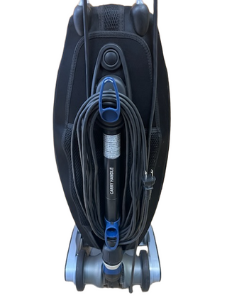 Back view of a refurbished Oreck Magnesium upright vacuum cleaner with a black cord wrapped around a central handle.