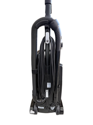 The Riccar R25 Standard by Imagine Sewing & Vacuum is a black upright vacuum with a self-adjusting brushroll, coiled power cord, and rear hose, displayed against a white background.