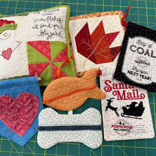Layton In-Store Class: Beginner's Machine Embroidery (3rd Monday, 4-6 pm)—learn to create quilted and embroidered pouches and ornaments with snowman, leaf, fish, bone, heart, and holiday designs! Perfect for beginners; projects displayed on a green cutting mat.