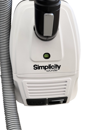 The Imagine Sewing & Vacuum Simplicity Wonder canister vacuum features Tandem Air technology, a hose attachment, green indicator light, and control switches on a white body.