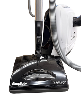A close-up view of the Simplicity Wonder vacuum cleaner by Imagine Sewing & Vacuum, highlighting the base, hose, and handle with advanced Tandem Air technology.