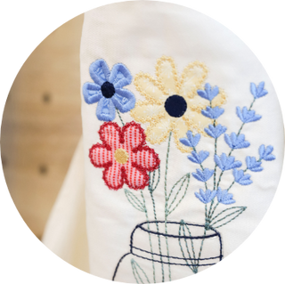 Embroidered colorful flowers in a jar on white fabric, inspired by the Layton In-Store Class: Kimberbell "Just Add Butter" 1-Day In-Person Only Event on February 28, 2026—perfect for your next cottagecore embroidery project!.