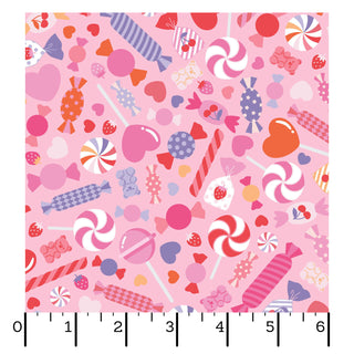 Kimberbell Maywood Studios Sweet Shoppe Candy Salad Pink MAS11022-P features assorted candies, lollipops, and hearts on pink fabric—shown with an inch ruler, ideal for quilting cotton projects. Brand: Maywood Studios.
