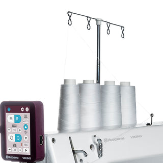 A Husqvarna Viking Platinum Q160 Stationary Quilter With Table sewing machine with several spools of thread.