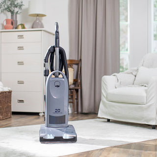 A durable Tandem Air Deluxe Upright Vacuum Anniversary Model by 10-Tacony, with HEPA media filtration, providing powerful suction, efficiently cleaning a living room.