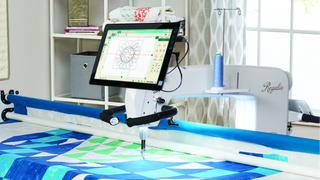 A Sew & Vac quilting machine equipped with an iPad for loading a quilt and threading the Introduction to Longarming & Pro Stitcher- Inst-Layton efficiently. It also includes the advanced Pro-Stitcher feature.