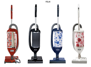 Four Sebo Felix Premium upright vacuums by Sew & Vac—red, black, blue, and white with unique patterned panels—stand side by side against a white background. "FELIX" is labeled above to highlight their multi-surface cleaning power.
