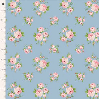 The Tilda Sunday Brunch MILLE SKY TIL100599 fabric by Tilda features blue premium quilting cotton with pink roses and green leaves, shown next to a ruler for scale—ideal for romantic floral fabric projects.
