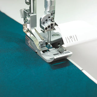 A Baby Lock Triumph Serger sewing machine is being used to sew a piece of fabric.