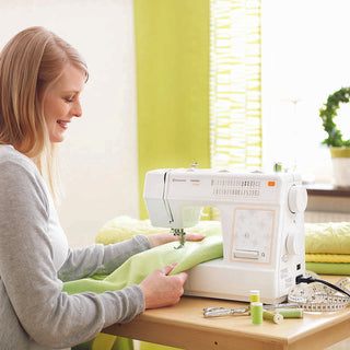 A woman using a Husqvarna Viking sewing machine.