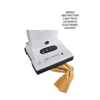 The SEBO Automatic X4 White by Vacuums 360 is an upright automatic vacuum displaying a brush obstruction light, with electronic shutoff and automatic height adjustment for effective pet hair removal—even when a cloth is stuck in the brush.