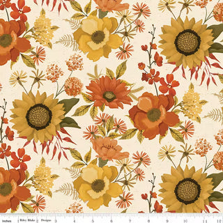 Bountiful by Sandy Gervais for Riley Blake (C17860-CREAM MAIN CREAM) features a pattern of yellow, orange, and gold flowers with green leaves on a cream background, crafted from premium quilting fabric. A ruler at the bottom edge shows scale in inches.