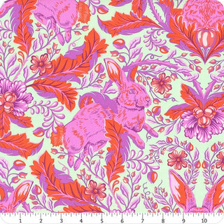 Discover the Tula Pink Full Moon Forest II PWTP.246-BLOSSOM Hoppy Go Lucky Fabric Yardage from Free Spirit TULA PINK, a whimsical quilting cotton adorned with pink and purple rabbits nestled among vibrant red and purple foliage and flowers, complete with a measurement ruler along the bottom edge.
