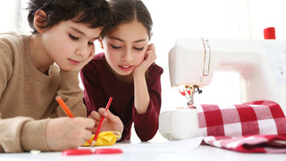 Two children working on a Sew & Vac sewing machine, Sewing with Tamra Layton.