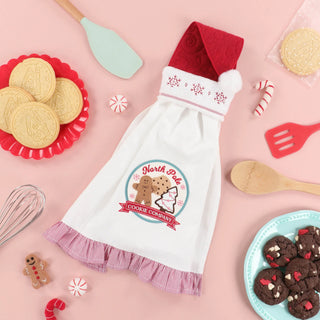 Get inspired for your next holiday embroidery project with a festive pink backdrop featuring Holiday baking items, cookies, peppermint candies, utensils, a gingerbread cookie, and a towel reading “North Pole Cookie Company”—all perfect for your Kimberbell Mrs. Claus’ Bakery One-Day Layton Event on October 10, 2026 at our Layton In-Store Class!.